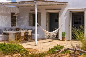 Front balcony is shown with the marble table the hammock under the shade of the pergola.