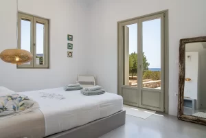 The master bedroom: showing the roomy space, the balcony doors and the amazing sea view and the old style full body mirror